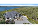 An elegant waterfront estate featuring a circular driveway, meticulous landscaping, and an attached private dock at 6178 9Th Avenue Ne Cir, Bradenton, FL 34212