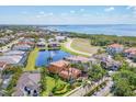 An aerial view of a stunning home near the water, featuring a pond and lush landscaping at 6211 Legends Blvd, Bradenton, FL 34210