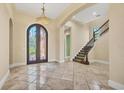 Spacious foyer with decorative tile flooring, a grand arched doorway, and an elegant staircase at 6211 Legends Blvd, Bradenton, FL 34210