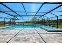 Stunning screened pool and spa with brick pavers overlooking a lush backyard at 9487 Tequila Sunrise Dr, Sarasota, FL 34241