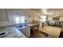 Functional kitchen with modern countertops and stainless steel sink, adjacent to a cozy sitting area at 10315 Cortez W Rd # 16E, Bradenton, FL 34210