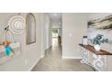 Welcoming entryway with neutral walls, decorative accents, and tile flooring leading to a bright living space at 11826 Davis Dr, Largo, FL 33774