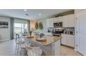 Modern kitchen featuring white cabinets, granite countertops, stainless steel appliances, and a breakfast bar with seating at 12128 Kingsley Trl, Parrish, FL 34219
