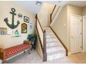 Welcoming foyer with staircase, decorative anchor, bench, and tile flooring at 12518 Harbour Landings Dr, Cortez, FL 34215