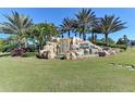 Striking waterfall feature with rock landscaping and lush greenery adds a touch of nature to the community entrance at 167 Wandering Wetlands Cir, Bradenton, FL 34212