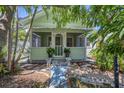 Charming cottage-style home with a quaint front porch and lush tropical landscaping at 1679 Arlington St, Sarasota, FL 34239