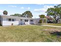 Charming single-story home with a carport and a well-manicured lawn on a sunny day at 1827 Nevada Ne Ave, St Petersburg, FL 33703