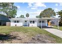 Charming single-story home with a carport and a well-manicured lawn on a sunny day at 1827 Nevada Ne Ave, St Petersburg, FL 33703