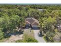Beautiful aerial view showing the home nestled among mature trees with a long driveway leading to a two-car garage at 2301 Bern Creek Loop, Sarasota, FL 34240
