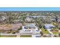 Scenic aerial showcasing this stunning yellow home with lush landscaping and community amenities nearby at 240 Spaniards Rd, Placida, FL 33946