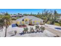 Captivating yellow home featuring lush landscaping, a well-manicured lawn, and a welcoming entrance at 240 Spaniards Rd, Placida, FL 33946