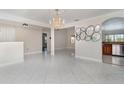 Spacious living room featuring tiled flooring, a decorative chandelier, and archways to other living spaces at 26506 Copiapo Cir, Punta Gorda, FL 33983