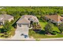 Stunning home featuring a three-car garage, lush landscaping, and a well-manicured lawn at 391 Snapdragon Loop, Bradenton, FL 34212