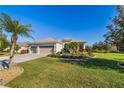 Charming single-story home with a well-manicured lawn and three-car garage, lush landscaping and a paver driveway at 391 Snapdragon Loop, Bradenton, FL 34212