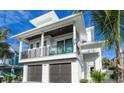 Stunning view of this two-story home featuring a balcony and two-car garage at 421 Spring Ave, Anna Maria, FL 34216