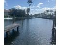 Picturesque waterfront view with a wooden dock, showcasing the beautiful canal and surrounding palm trees at 502 69Th St, Holmes Beach, FL 34217
