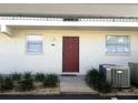 Exterior of condo featuring covered parking, a red door, and minimal landscaping at 507 Parkdale Mews # 507, Venice, FL 34285