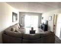 Spacious living room with wood floors, comfortable sectional sofa, and sliding glass doors at 507 Parkdale Mews # 507, Venice, FL 34285