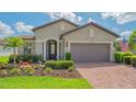 Attractive front entrance featuring an elegant front door, columns, and beautiful landscaping at 5562 Rain Lily Ct, Sarasota, FL 34238