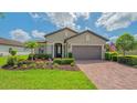 Charming single-story home with a brick driveway, meticulous landscaping, and an American flag at 5562 Rain Lily Ct, Sarasota, FL 34238