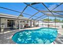 Sparkling in-ground pool within screened enclosure, complemented by ample seating and partially covered patio area at 5611 22Nd E St, Bradenton, FL 34203