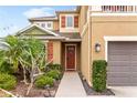 Tan two-story home with front yard landscaping and dark-stained wood front door with sidelight and decorative shutters at 5954 Anise Dr, Sarasota, FL 34238