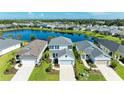 Beautiful aerial view of a two-story home in a lakeside community with manicured lawns and lush landscaping at 10614 Morning Marsh Ln, Parrish, FL 34219