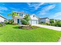 Inviting two-story home featuring a well-manicured lawn and a charming front entrance at 10614 Morning Marsh Ln, Parrish, FL 34219