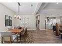 Dining room with modern chandelier, art, and wooden table at 12352 Auburndale Ct, Venice, FL 34293