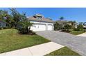 Beautiful home with a paved driveway, a well maintained lawn, and a 2-car garage at 12352 Auburndale Ct, Venice, FL 34293