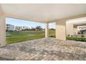 Spacious covered patio with beautiful gray pavers and an inviting view of the green common at 12413 Gulf Breeze Ter, Cortez, FL 34215