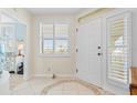 Bright foyer with white door, sidelights, shuttered window, and decorative tiled floor at 1260 Dolphin Bay Way # 404, Sarasota, FL 34242