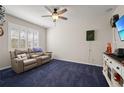 Comfortable living room featuring plush seating, ceiling fan, and ample natural light at 12755 Rainwashed Loop, Parrish, FL 34219