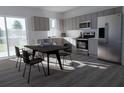 Well-lit kitchen with stainless steel appliances, lots of cabinet space, and a dining area with modern dark table at 13034 Bayberry Way, Parrish, FL 34219
