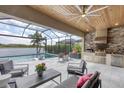 Screened patio featuring an outdoor kitchen, grill, seating, and a swimming pool with a lake view at 17604 Hickok Belt Loop, Bradenton, FL 34211
