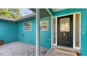 Cozy front porch with decorative glass door and beautiful turquoise exterior at 2261 Linwood Dr, Sarasota, FL 34232