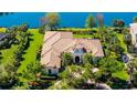 Expansive home with a tile roof, tower entry, and well-manicured lawn near the water at 3153 Founders Club Dr, Sarasota, FL 34240