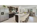 Modern kitchen featuring stainless steel appliances, a breakfast bar and dark wood cabinetry at 4104 112Th E St, Palmetto, FL 34221