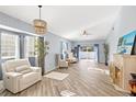Light-filled living area showcases wood-style floors, a cozy fireplace, and sliding glass doors to the backyard at 411 28Th W St, Palmetto, FL 34221