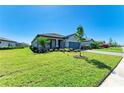 Beautiful single-story home featuring a manicured lawn, lush landscaping, and paved driveway at 5129 Marina Basin Ct, Bradenton, FL 34211