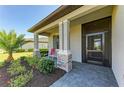 Inviting front porch with stone accents, tiled floor, and a screened front door at 5129 Marina Basin Ct, Bradenton, FL 34211