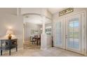 Bright foyer with white tile flooring, decorative column, neutral walls, and a view into the dining area beyond at 5518 Eastwind Dr, Sarasota, FL 34233