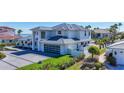 Modern two-story home with a sleek design, glass garage door, and well-manicured lawn at 560 Schooner Ln, Longboat Key, FL 34228