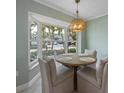 Bright dining room with a round table, seating for four, and a bay window overlooking the street at 611 Dundee Ln, Holmes Beach, FL 34217