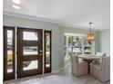 Cozy dining area featuring a front door, stylish pendant lighting, and an inviting view at 611 Dundee Ln, Holmes Beach, FL 34217