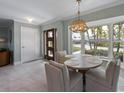 Dining room with a table, bay window, stylish chandelier, and view of the entryway at 611 Dundee Ln, Holmes Beach, FL 34217