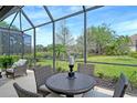 Relaxing screened lanai showcasing serene lake views and a cozy outdoor dining set at 7137 Orchid Island Pl, Bradenton, FL 34202