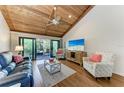 Cozy living room featuring a vaulted wood ceiling, comfortable seating, and access to the screened-in lanai at 7615 4Th W Ave # 7615, Bradenton, FL 34209