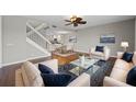 Inviting living room with hardwood floors, a ceiling fan, and an open view into the dining area and kitchen at 7665 Bergamo Ave, Sarasota, FL 34238