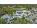 Aerial view of white tile roof home in a lush golf course community at 7782 Club Ln, Sarasota, FL 34238